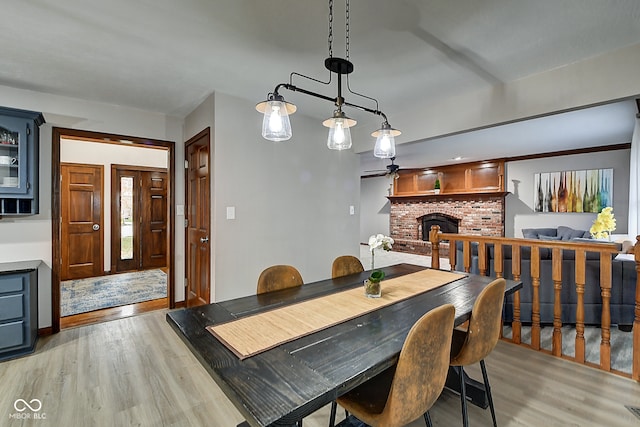 dining room with light wood-type flooring and a fireplace