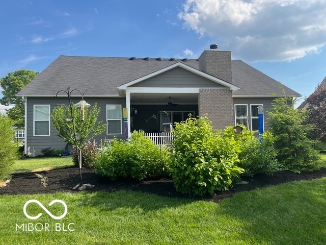 back of property with a lawn and a porch