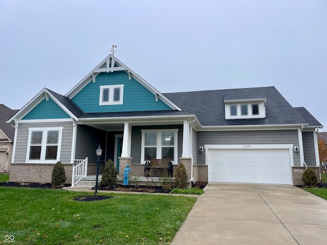 craftsman house with a garage, a front lawn, and a porch