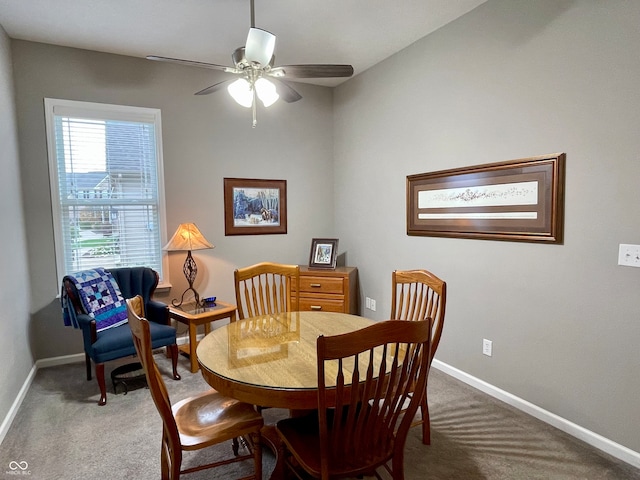 carpeted dining space with ceiling fan