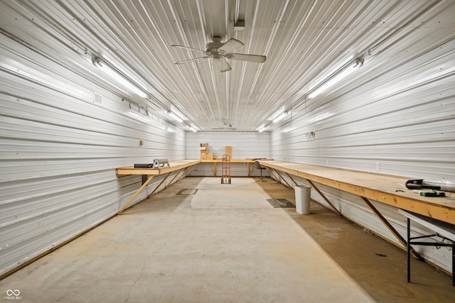 miscellaneous room featuring metal wall, a workshop area, and concrete flooring