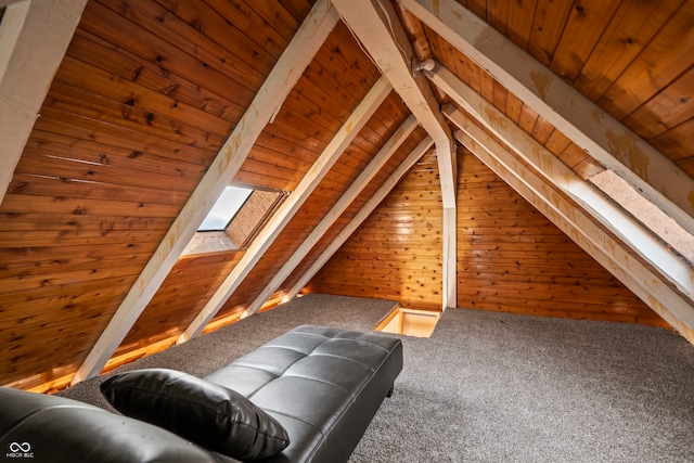 interior space with lofted ceiling with skylight, wooden walls, wood ceiling, and carpet