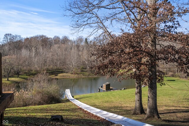 exterior space with a water view, a lawn, and a dock