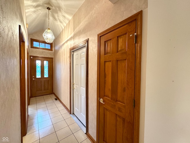 entryway featuring light tile patterned floors and vaulted ceiling