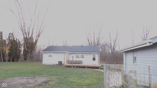 back of house featuring a lawn and a wooden deck