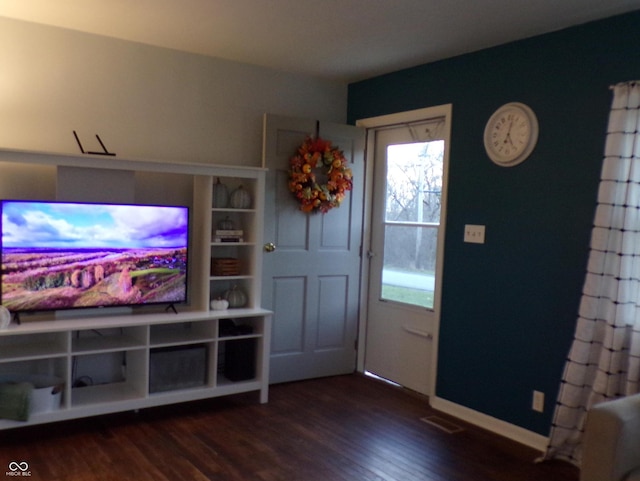 entryway with dark hardwood / wood-style flooring and a healthy amount of sunlight