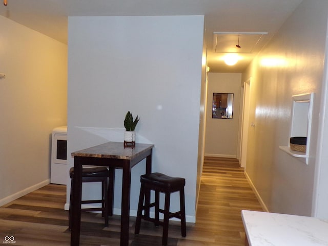 dining room featuring washer / dryer and dark wood-type flooring