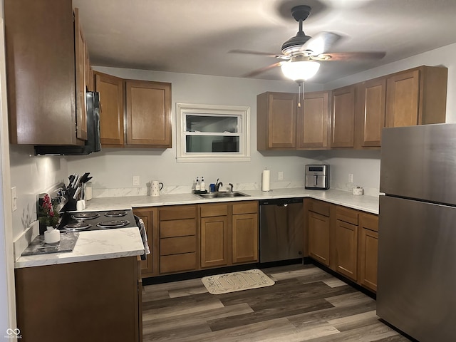 kitchen featuring dark hardwood / wood-style flooring, stainless steel appliances, ceiling fan, and sink