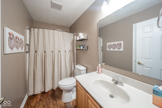 bathroom featuring vanity, hardwood / wood-style flooring, and toilet