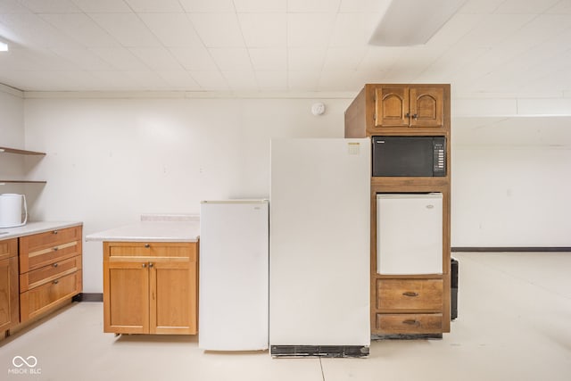 kitchen featuring white fridge and black microwave