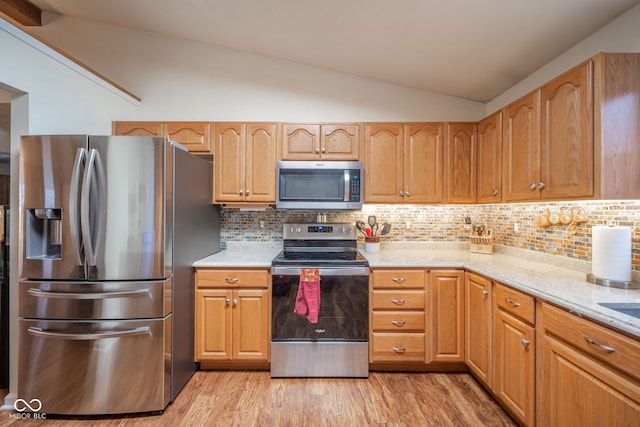 kitchen with light stone countertops, stainless steel appliances, light hardwood / wood-style floors, lofted ceiling, and decorative backsplash