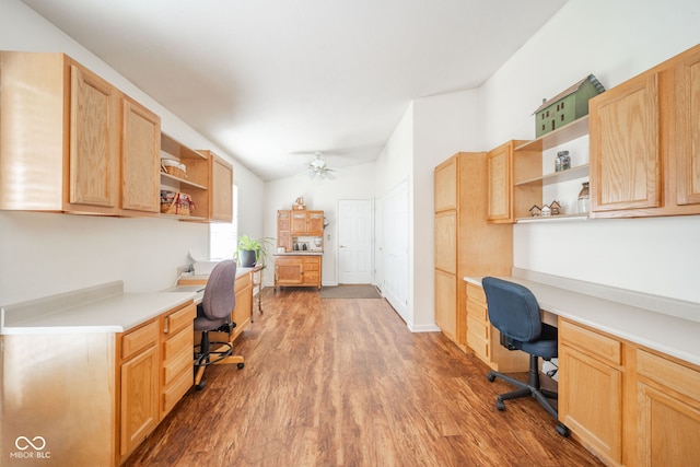 office with hardwood / wood-style flooring, ceiling fan, built in desk, and vaulted ceiling