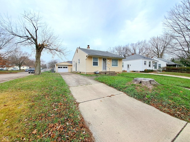 view of front facade featuring an outbuilding, a front yard, and a garage