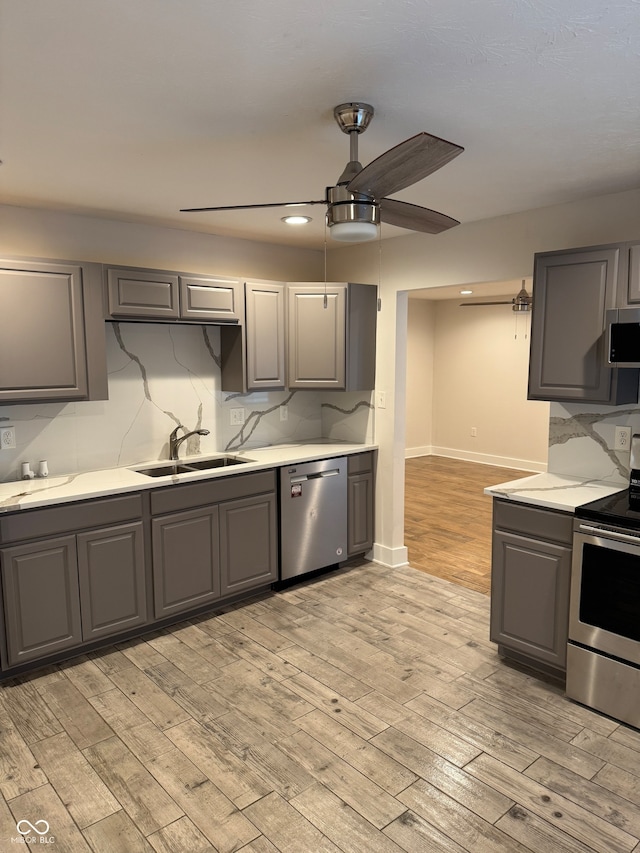 kitchen with gray cabinets, sink, stainless steel appliances, and light hardwood / wood-style floors