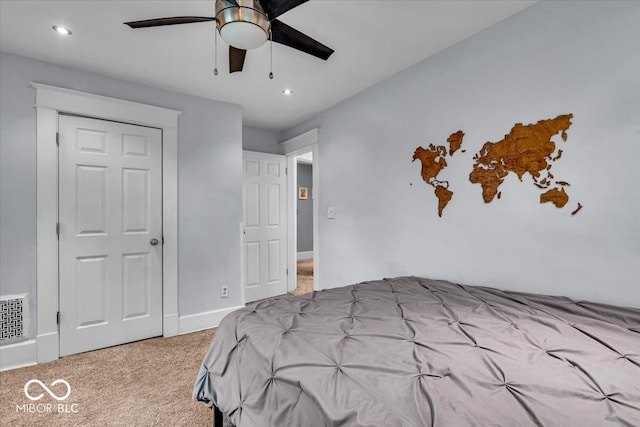 carpeted bedroom featuring ceiling fan and a closet