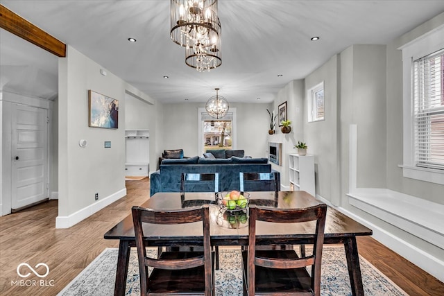 dining area with light hardwood / wood-style flooring and a notable chandelier