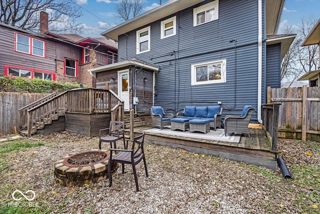 back of house featuring an outdoor living space with a fire pit and a deck