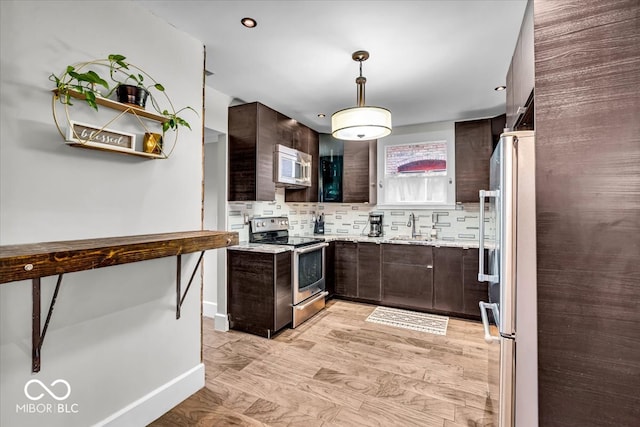 kitchen with sink, tasteful backsplash, decorative light fixtures, dark brown cabinetry, and stainless steel appliances