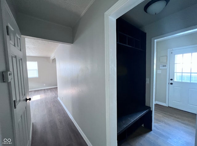 hallway with wood finished floors, baseboards, and a textured ceiling