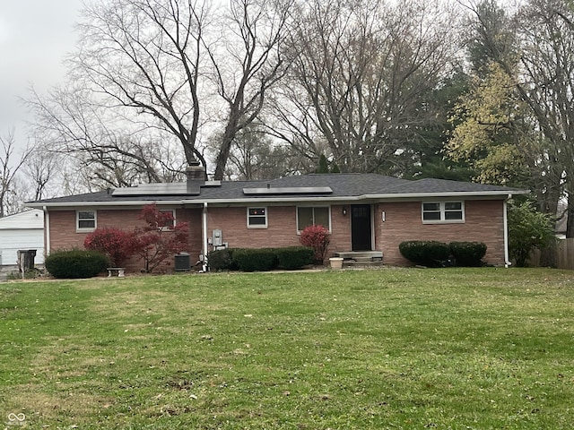 single story home with a garage, an outbuilding, and a front lawn