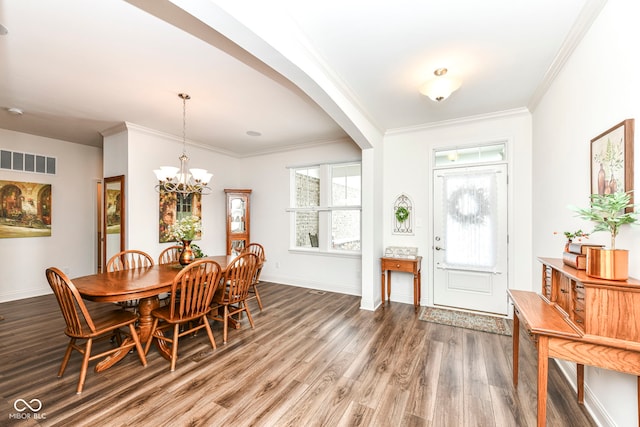 foyer entrance with hardwood / wood-style flooring, a notable chandelier, and ornamental molding