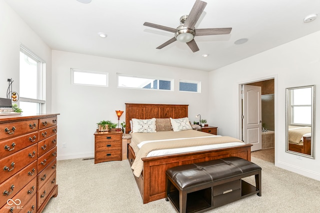 carpeted bedroom with ensuite bath and ceiling fan