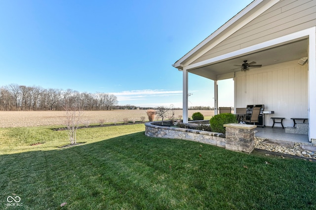 view of yard with a patio, a rural view, and ceiling fan