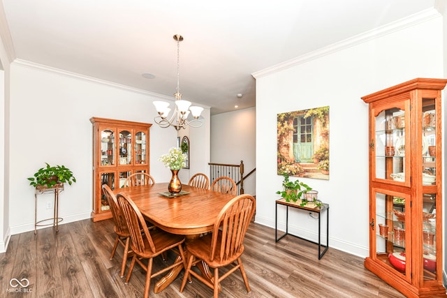 dining room with dark hardwood / wood-style flooring, an inviting chandelier, and ornamental molding