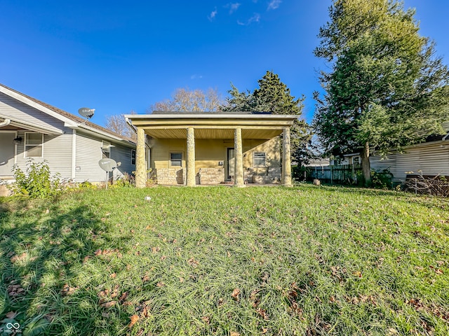 rear view of house featuring a lawn