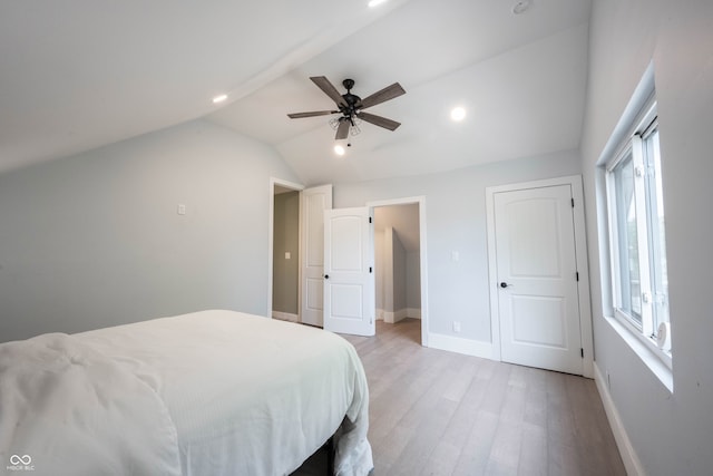 bedroom with ceiling fan, light hardwood / wood-style floors, and vaulted ceiling