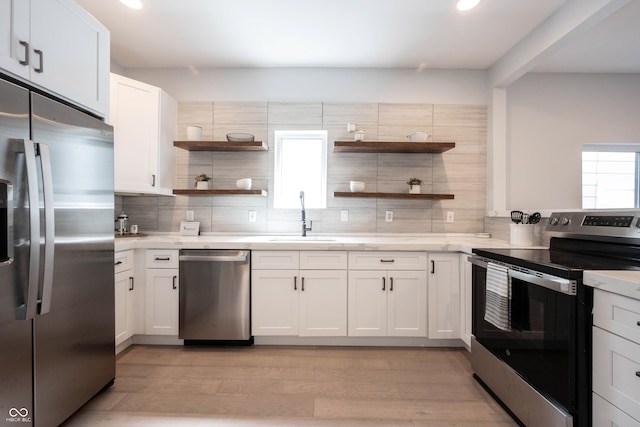 kitchen featuring white cabinets, stainless steel appliances, and light hardwood / wood-style flooring