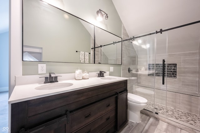 bathroom with hardwood / wood-style floors, vanity, lofted ceiling, toilet, and walk in shower