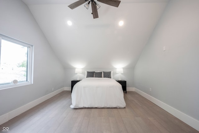 bedroom featuring ceiling fan, light hardwood / wood-style floors, and vaulted ceiling