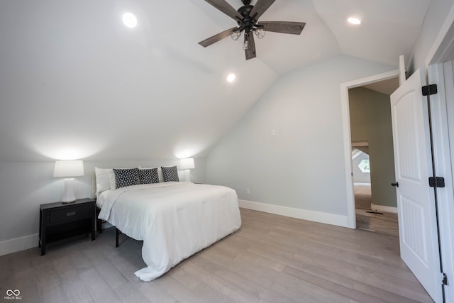 bedroom featuring ceiling fan, light hardwood / wood-style flooring, and lofted ceiling