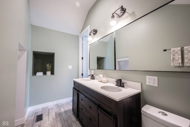 bathroom featuring hardwood / wood-style floors, vanity, toilet, and lofted ceiling