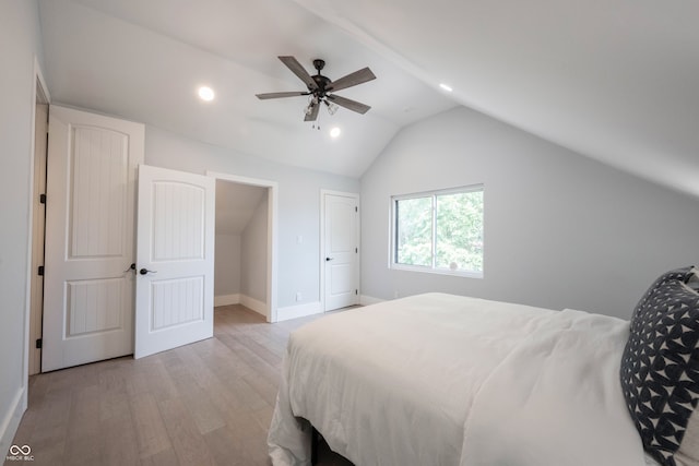 bedroom with ceiling fan, light wood-type flooring, and vaulted ceiling