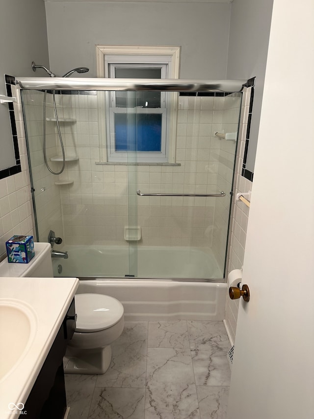 full bathroom featuring vanity, toilet, and bath / shower combo with glass door