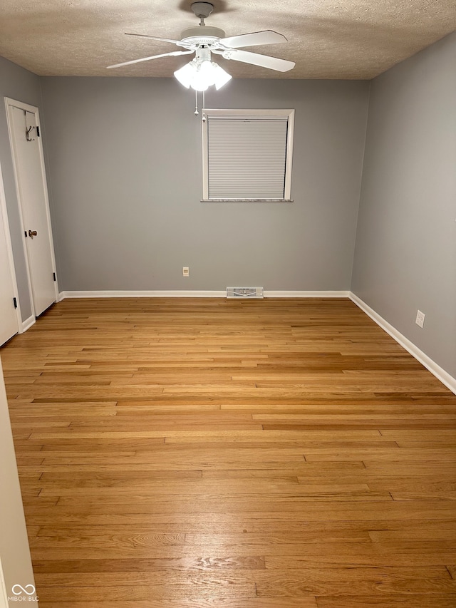 unfurnished room with a textured ceiling, light hardwood / wood-style flooring, and ceiling fan