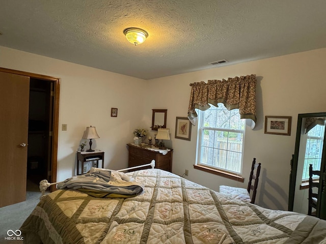 carpeted bedroom featuring a textured ceiling and a closet