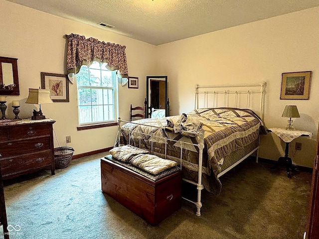 bedroom featuring dark colored carpet and a textured ceiling