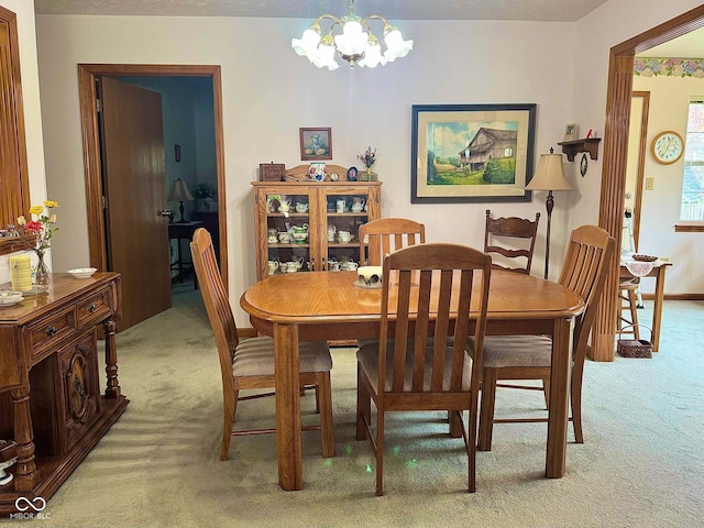 carpeted dining area featuring a chandelier