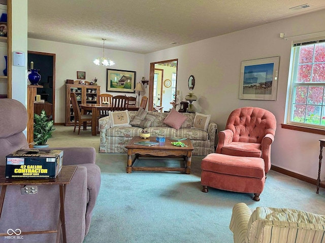 living room with carpet floors, a textured ceiling, and a notable chandelier