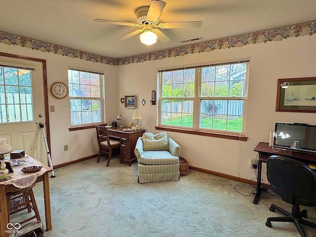 carpeted office space featuring ceiling fan