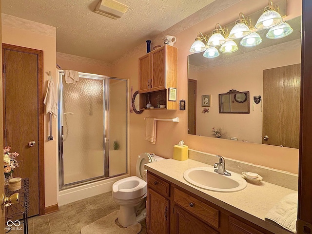 bathroom with vanity, a textured ceiling, and a shower with door