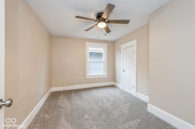 carpeted spare room featuring ceiling fan