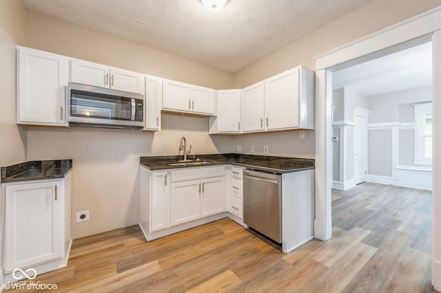 kitchen with light hardwood / wood-style floors, sink, white cabinetry, and stainless steel appliances