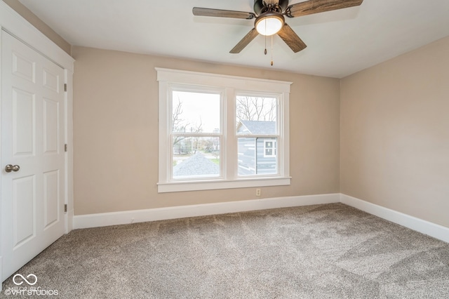 carpeted spare room with ceiling fan