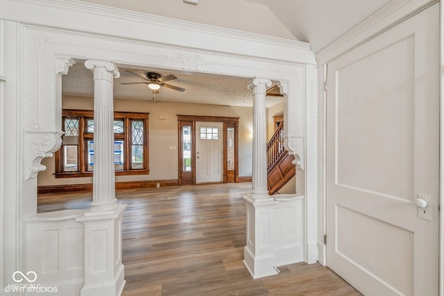 foyer featuring hardwood / wood-style flooring, ceiling fan, and ornate columns