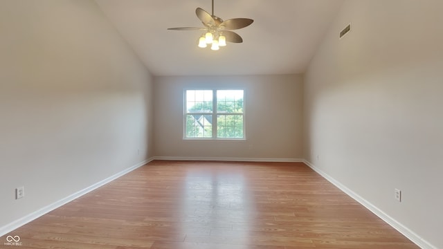 spare room featuring ceiling fan, vaulted ceiling, and light wood-type flooring