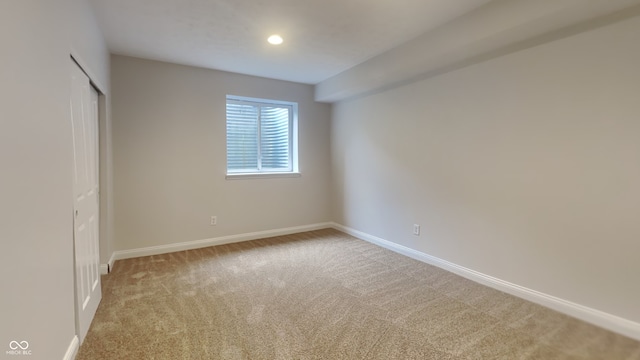 unfurnished bedroom featuring light colored carpet and a closet